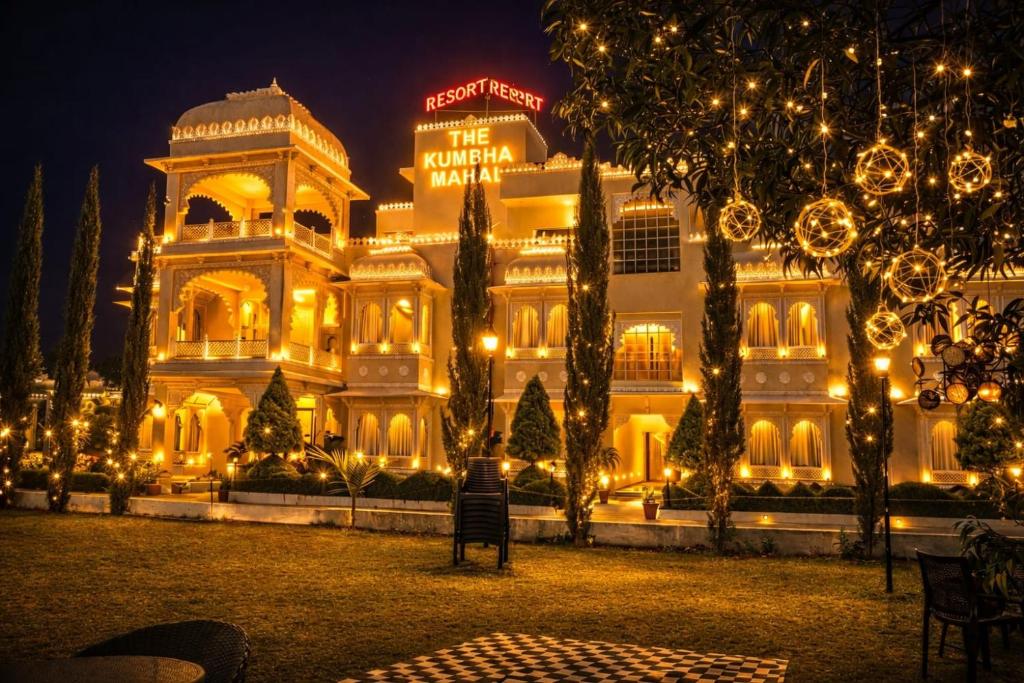 een groot gebouw met kerstverlichting ervoor bij The Kumbha Mahal Resort in Kumbhalgarh