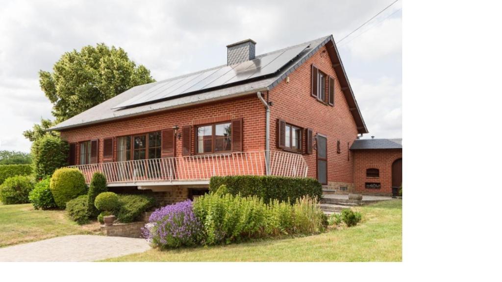 a red brick house with a solar roof at L'Echappée Belle in Beauraing