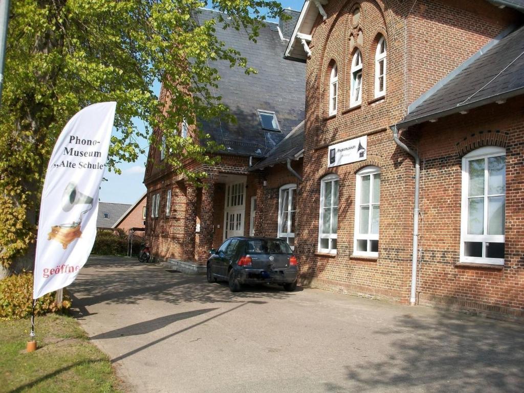 a sign in front of a brick building with a car at Apartment Fewo Berliner by Interhome in Holzdorf