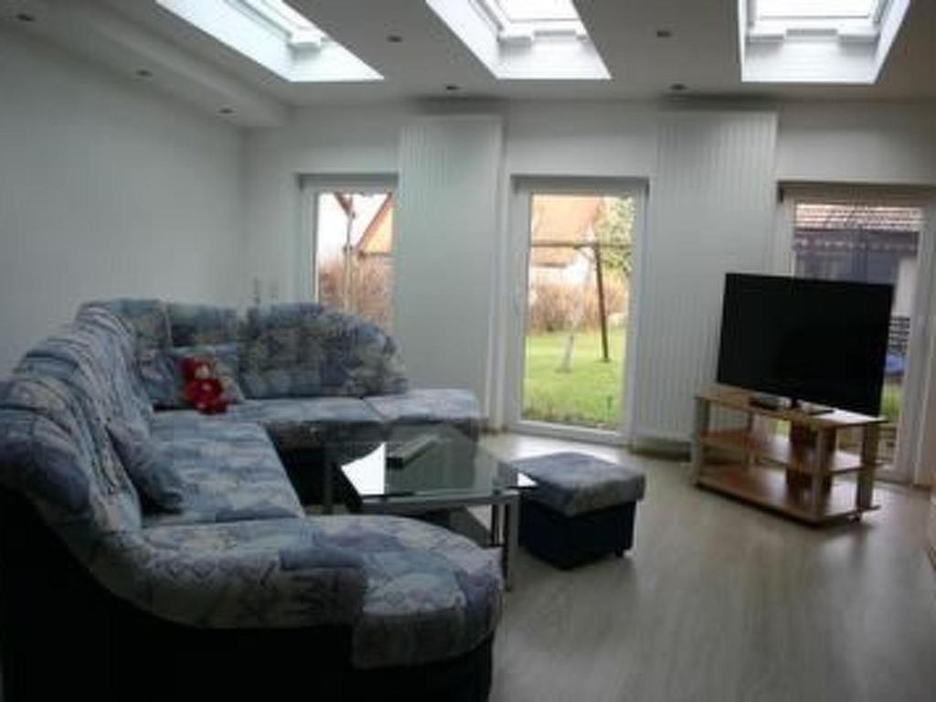 a living room with a couch and a flat screen tv at Apartment Lotta in Trochtelfingen by Interhome in Trochtelfingen