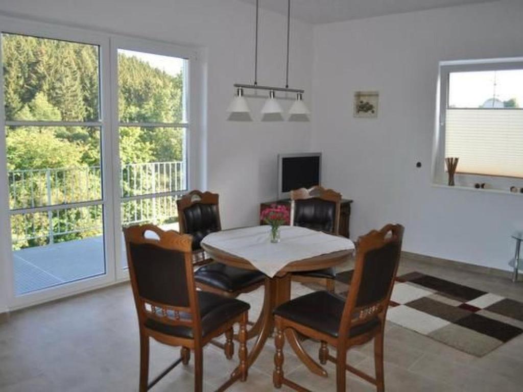 a dining room with a table and chairs and a window at Apartment am Waldesrand by Interhome in Schmallenberg
