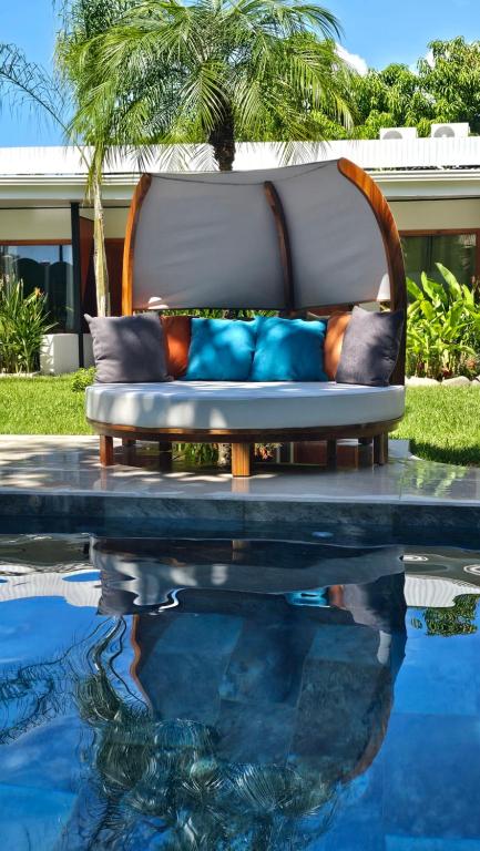 un divano accanto alla piscina di Los Papyrus a Bahia