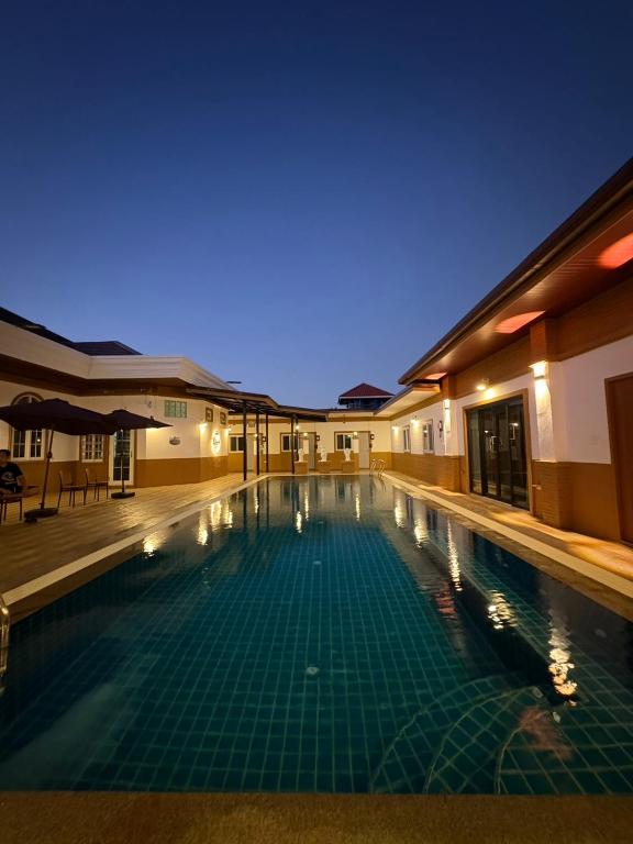 a swimming pool in a hotel at night at Jin Pool Villa in Ban Khok Chakohan