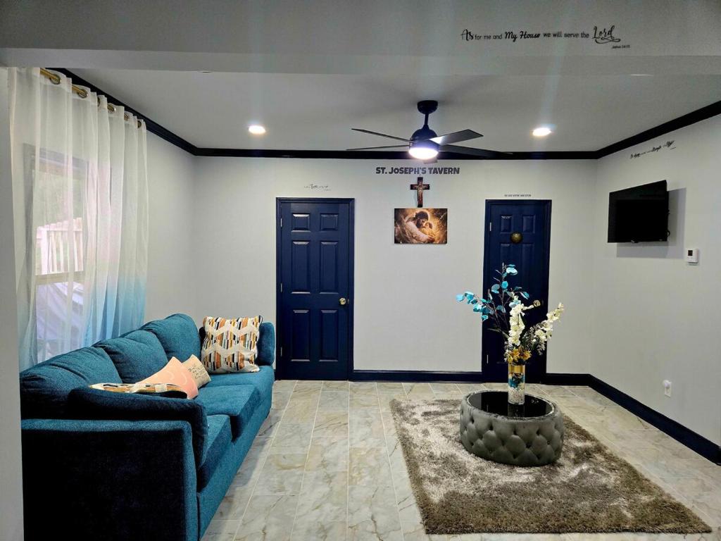 un soggiorno con divano blu e ventilatore a soffitto di St Joseph's Tavern a Dacula