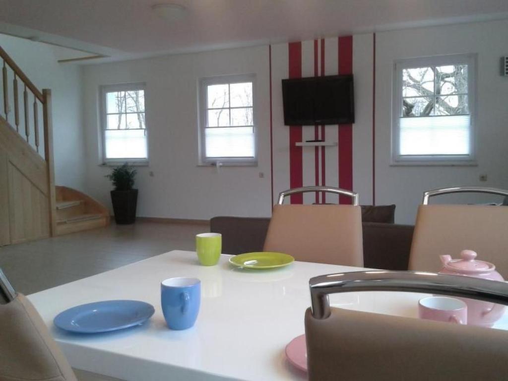 a table with plates and cups and a television in a living room at Apartment 4 by Interhome in Feldhusen