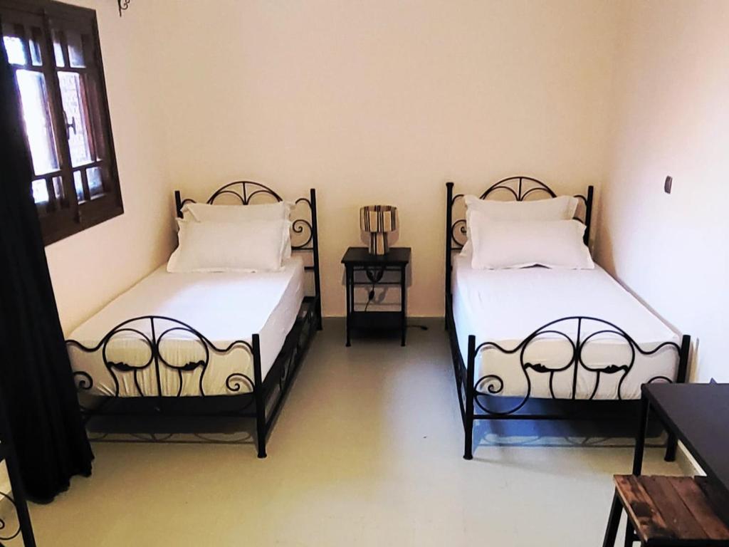een kamer met twee bedden in een kamer bij FERME D'HOTES BARGHALi in Marrakesh