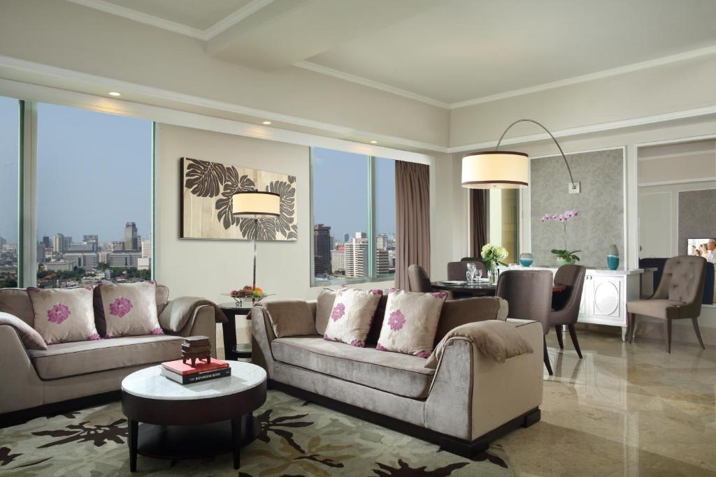 a living room with two couches and a table at Ascott Jakarta in Jakarta