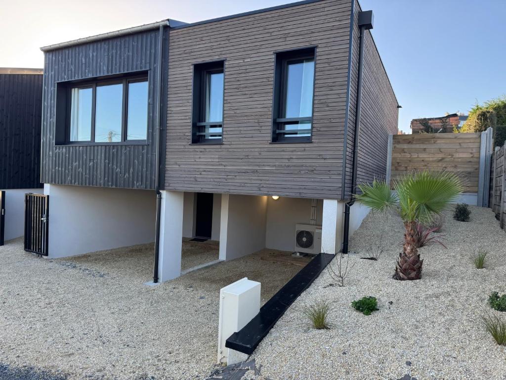 a modern house with a wooden facade at Lodges des Pontons - Cap Ouest - vue mer in Saint-Côme-de-Fresné