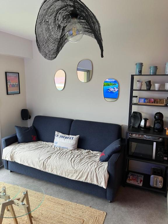 a bedroom with a blue couch and a shelf at La loge Royale in Cucq