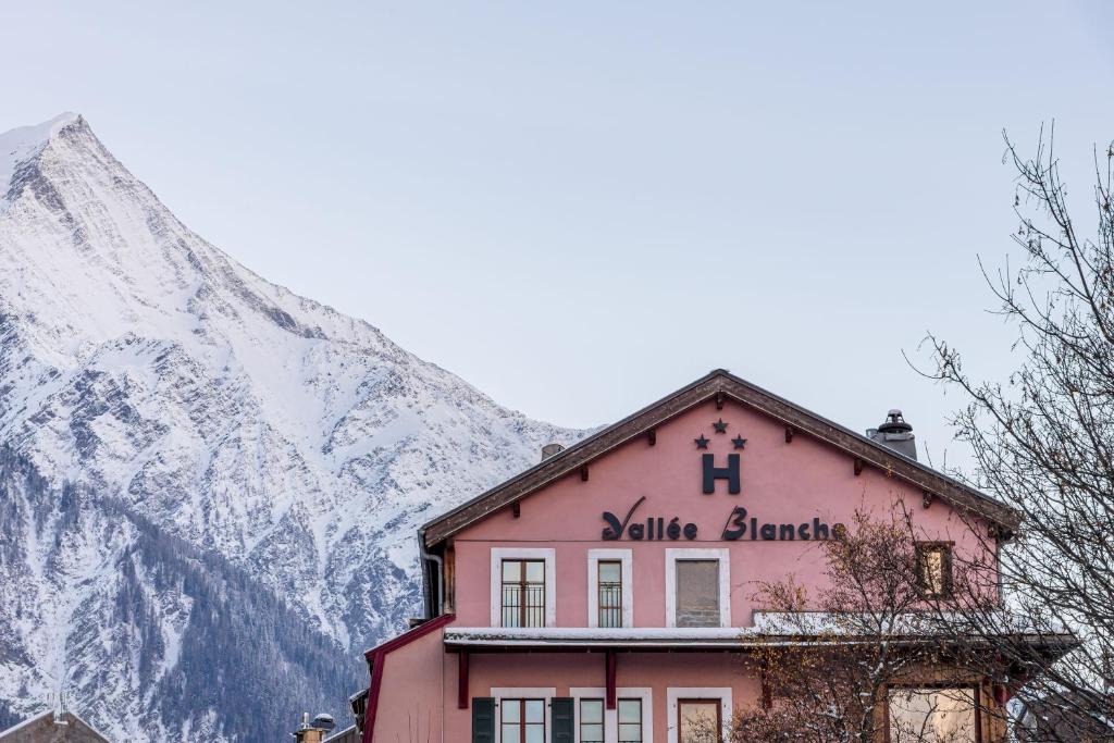 ein Gebäude vor einem schneebedeckten Berg in der Unterkunft Hôtel Vallée Blanche in Chamonix-Mont-Blanc