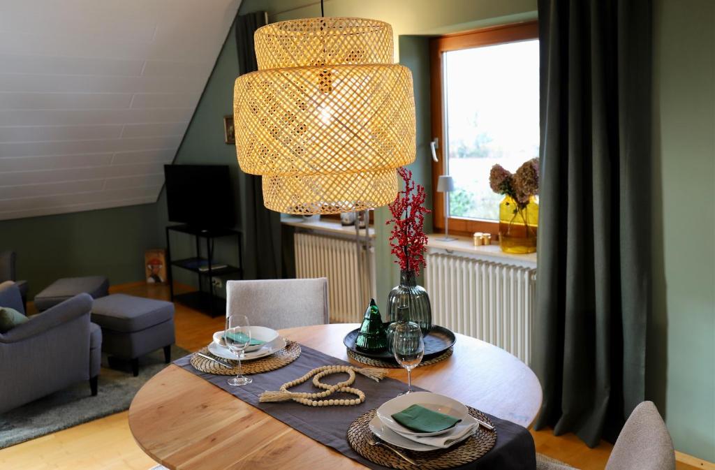 een eetkamer met een tafel en een kroonluchter bij Bühler Blick in Bühl