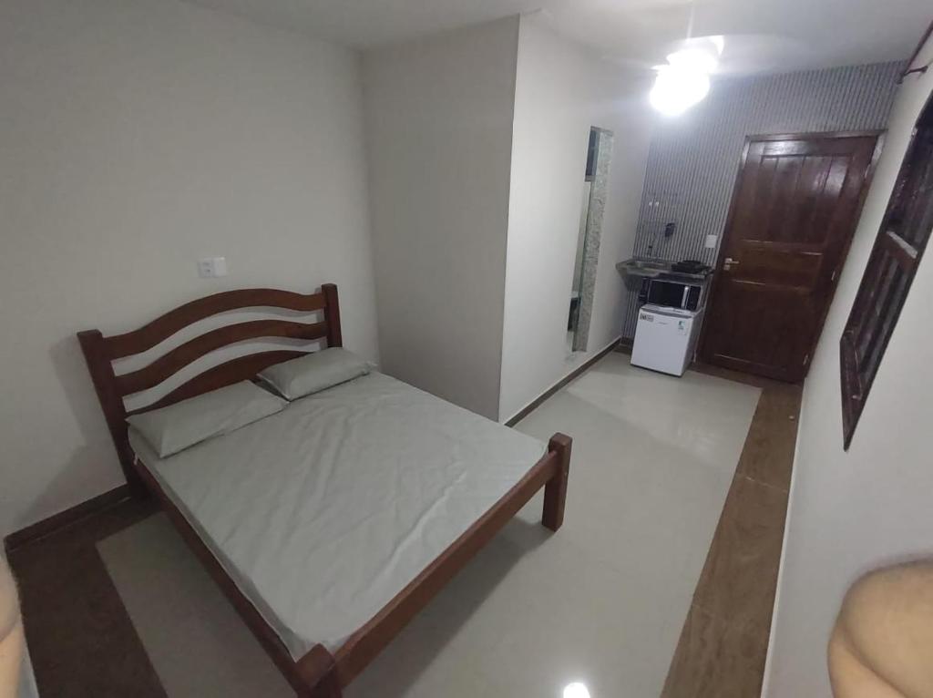 una piccola camera da letto con un letto in una stanza di Suite Ilha CasaMar hospedagem a Bertioga