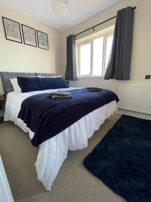 una camera con due letti con lenzuola blu e una finestra di 4 bed house perfect for contractors a Coseley