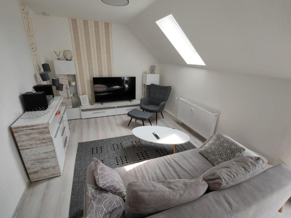 a living room with a couch and a tv at Apartment Urlaubszuhause by Interhome in Naundorf