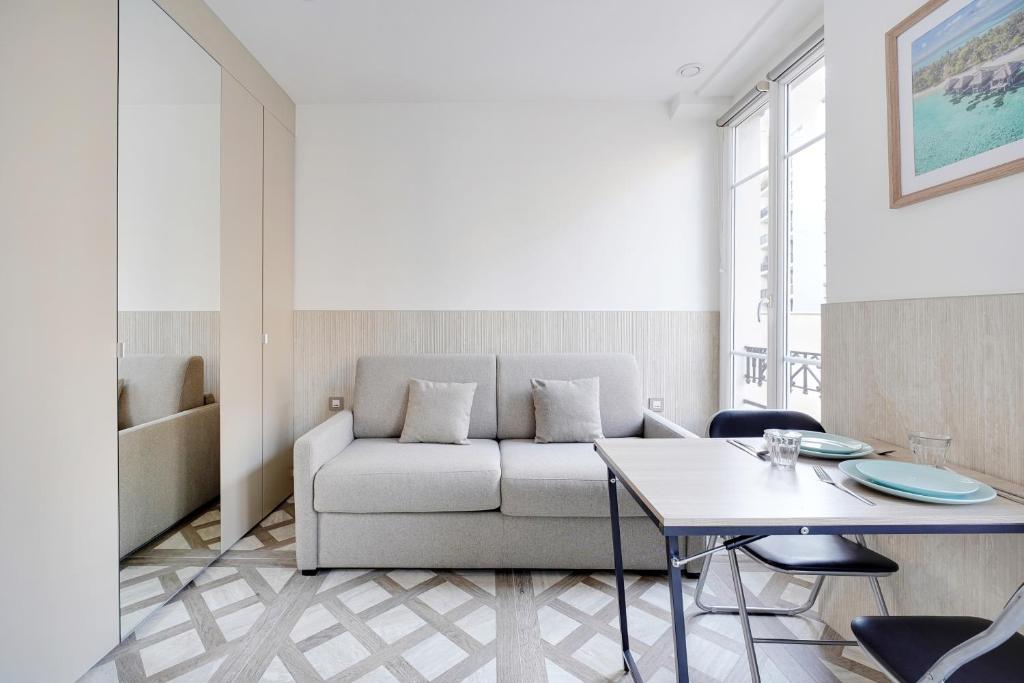 een woonkamer met een bank en een tafel bij Studio cosy - 2P - Bercy in Parijs