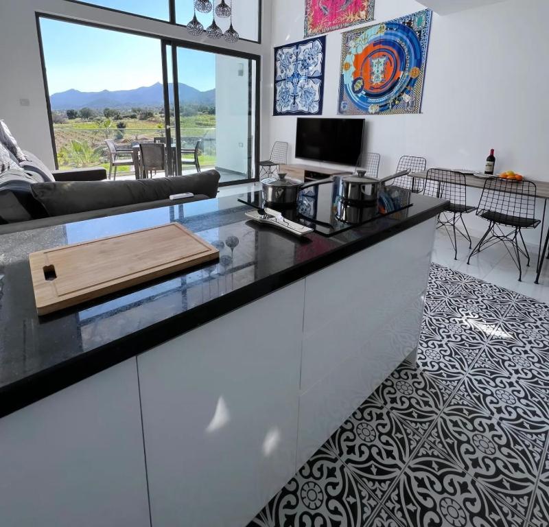 a kitchen with a counter top and a living room at Hermes Penthouse Sea Sky & Mountains in Akanthou