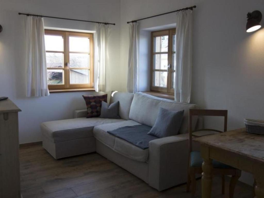 a living room with a couch and two windows at Apartment Apartment - Monteure by Interhome in Emmering