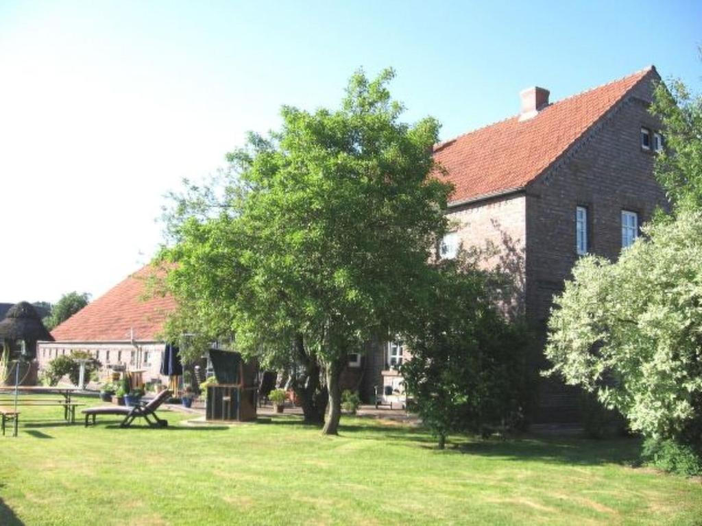 a building with a tree in front of a yard at Apartment Mooij Plaats by Interhome in Großefehn 