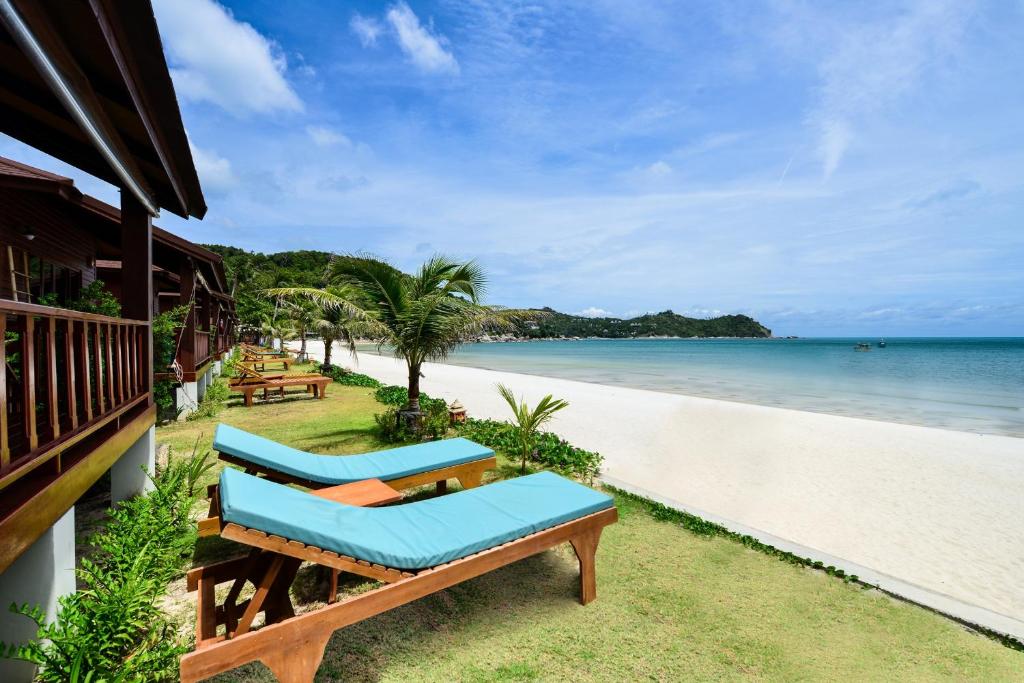 a beach with two lounge chairs and the ocean at PingChan Koh Phangan Beachfront Resort in Thong Nai Pan Yai