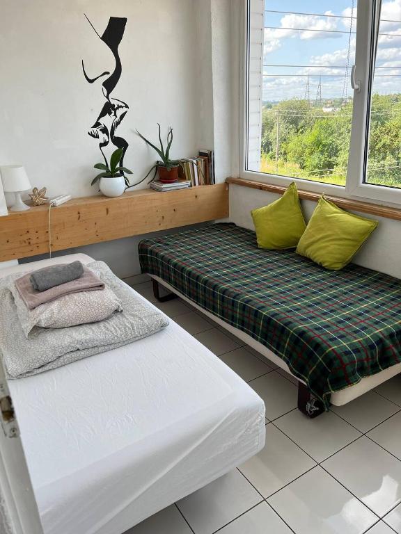 a living room with two beds and a window at Kaunas Homestay in Kaunas