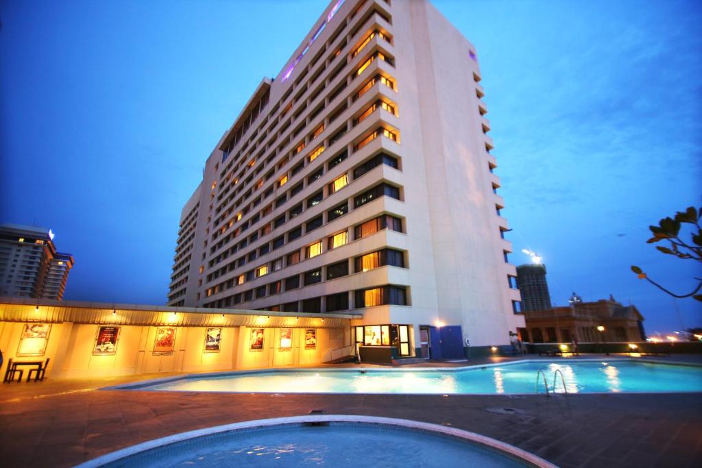 een gebouw met een zwembad voor een gebouw bij The Galadari Hotel in Colombo