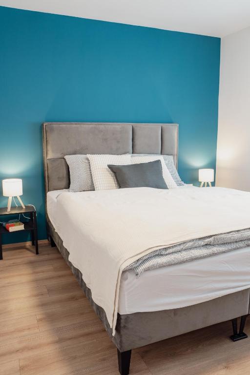 a bedroom with a large bed with a blue wall at Vanjkuš in Marija Bistrica