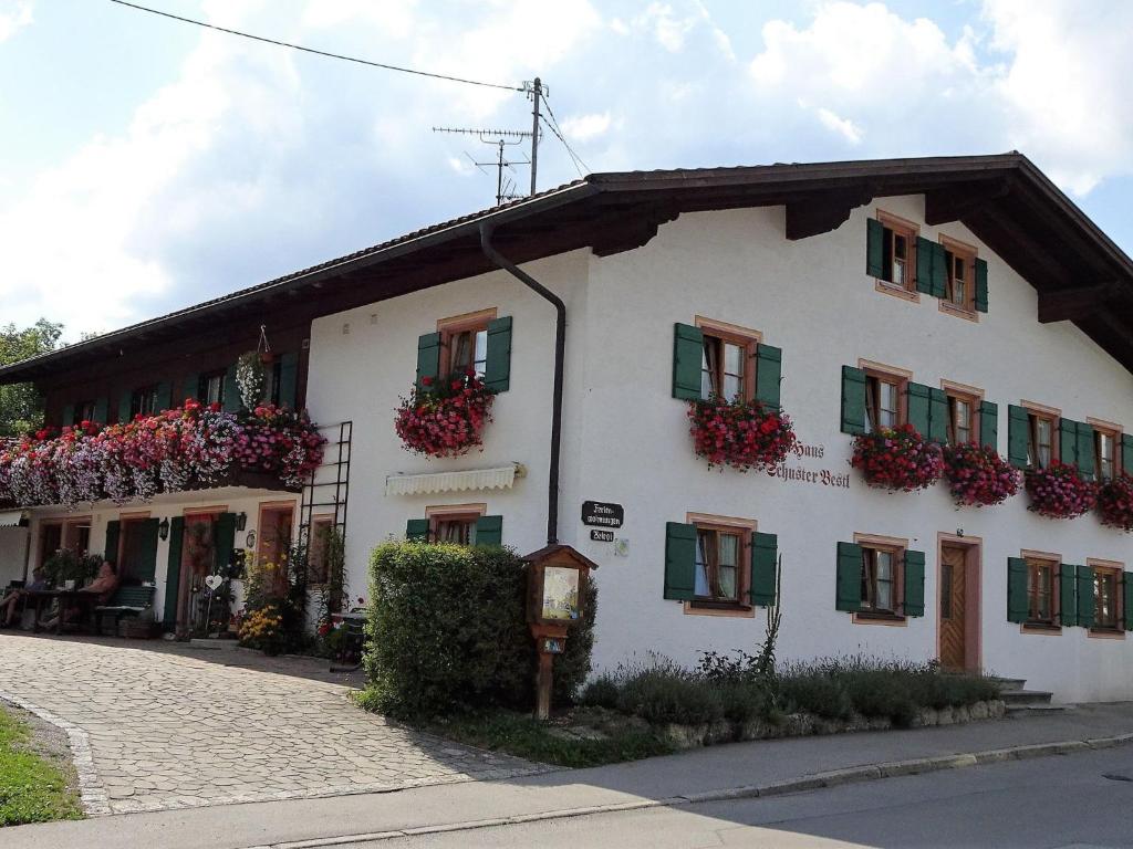 a white building with green shutters and flowers on it at Apartment Bärli by Interhome in Bad Bayersoien