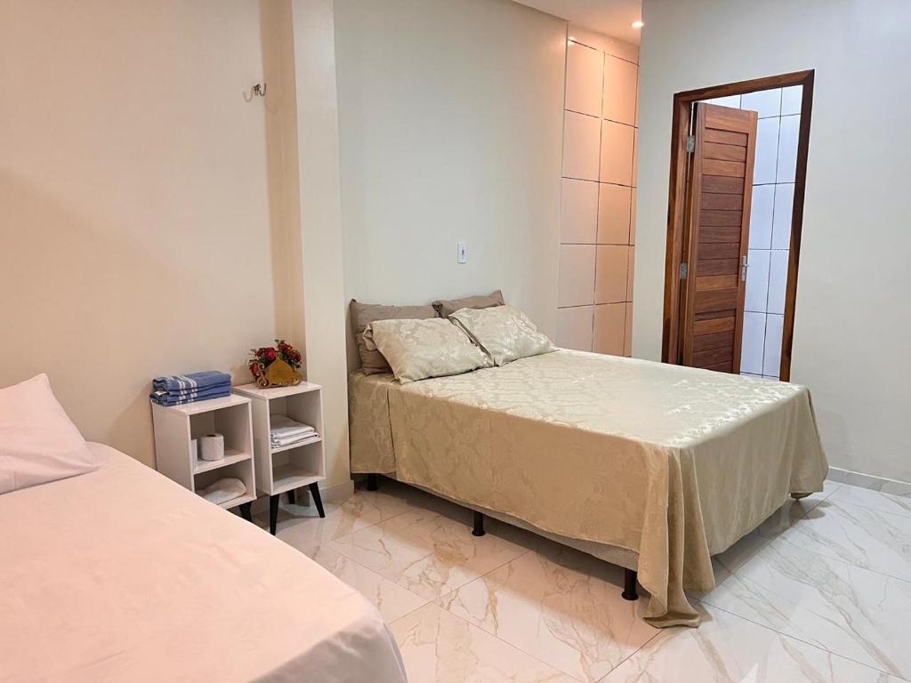 una camera da letto con due letti in una stanza di Flat com quarto e sala a Viçosa do Ceará