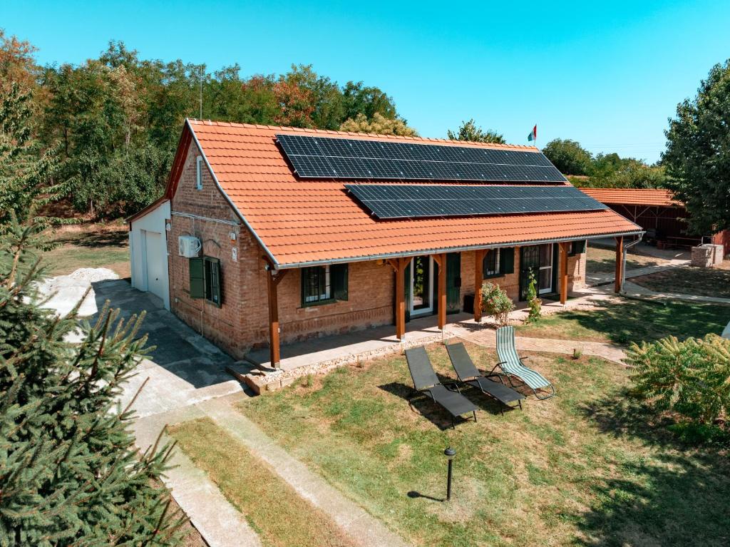 a house with solar panels on the roof at Abi-Lo Vendégház Nagypeterd in Nagypeterd