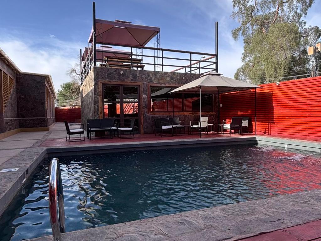 een huis met een zwembad en een gebouw bij Hotel Toconar in San Pedro de Atacama