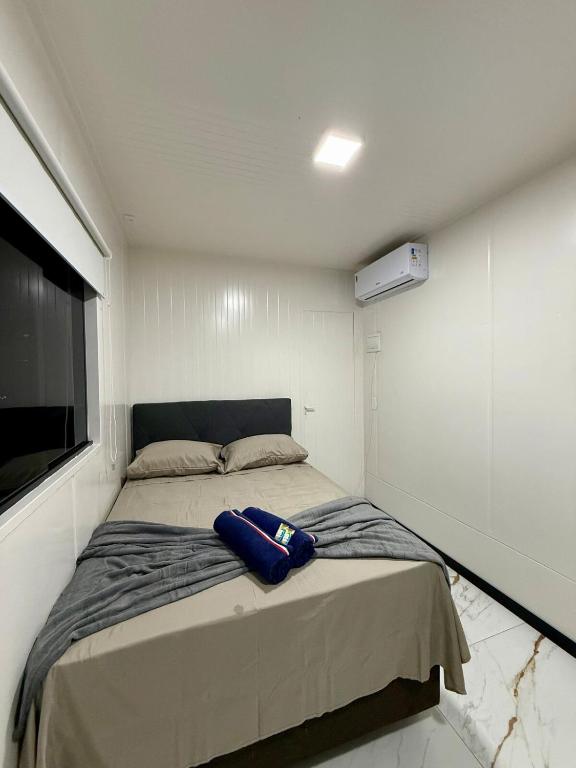 una piccola camera con letto e TV a schermo piatto di Loft 04 na Praia Brava a Itajaí