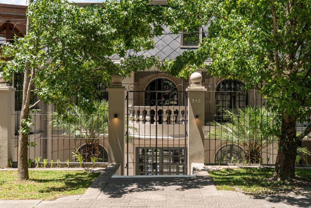 a gate in front of a building with trees at Trento Hotel Boutique in San Salvador de Jujuy