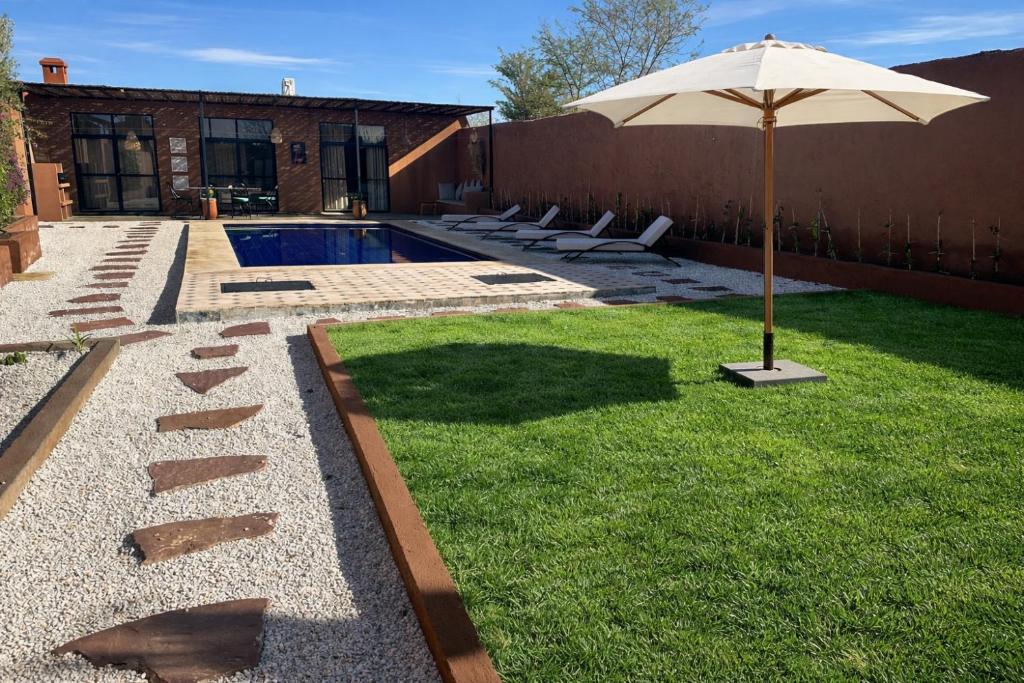 a patio with an umbrella and a swimming pool at Villa Léa in Marrakesh