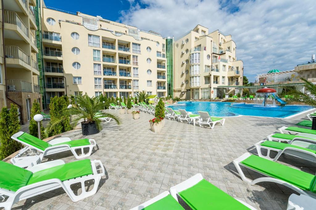 a swimming pool with lounge chairs and a resort at Apart Hotel Vechna R in Sunny Beach