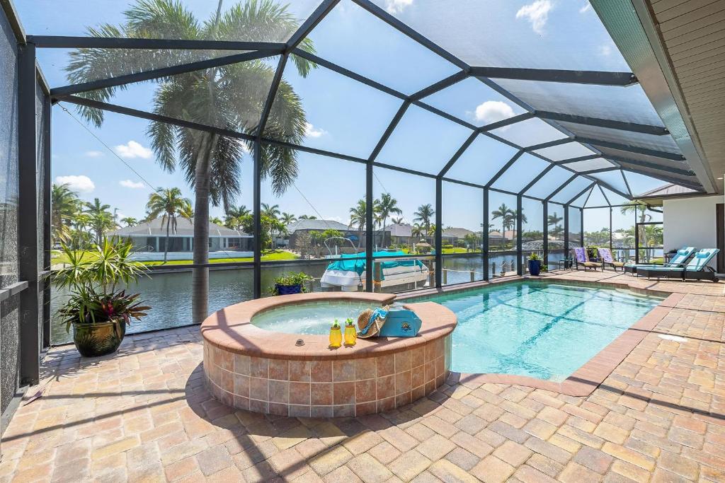 een zwembad in een glazen huis met een zonneklep bij Villa Pearl in Matlacha