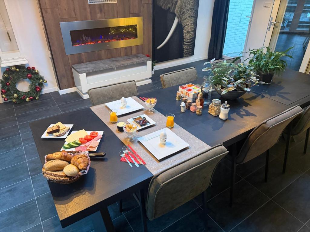 a long table with food on it with a fireplace at B&B Prachtig Allemachtig in Valkenburg