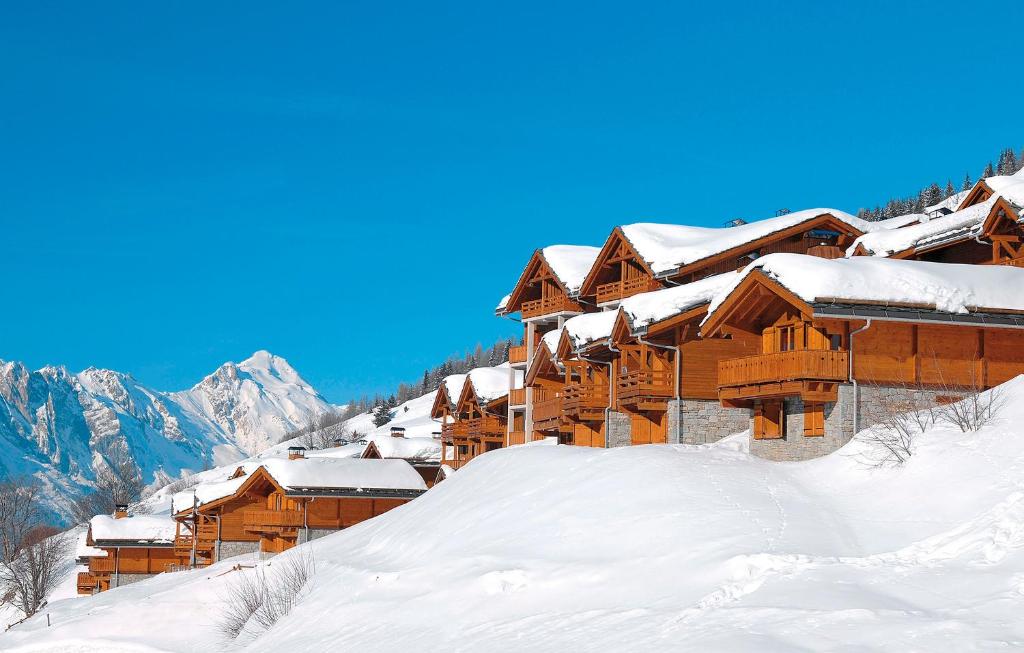 un lodge de ski dans la neige sur une montagne dans l'établissement Résidence Odalys Le Grand Panorama 1, à Valmeinier