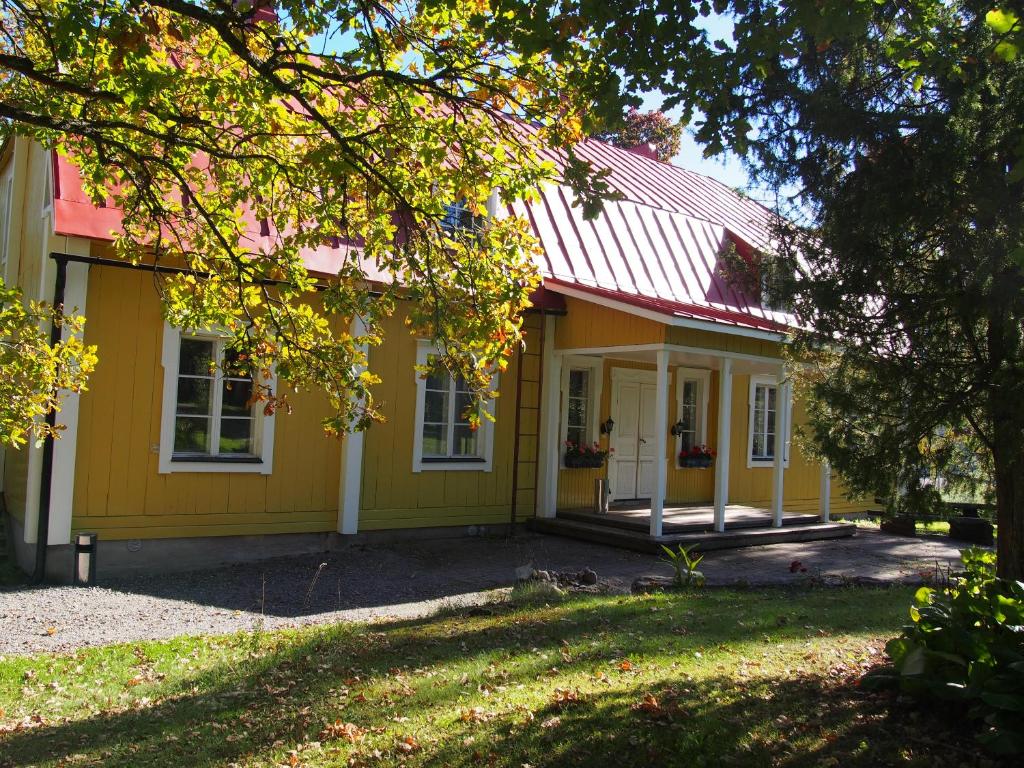 a yellow house with a red roof at Joensuun Tilan Päärakennus in Söderkulla