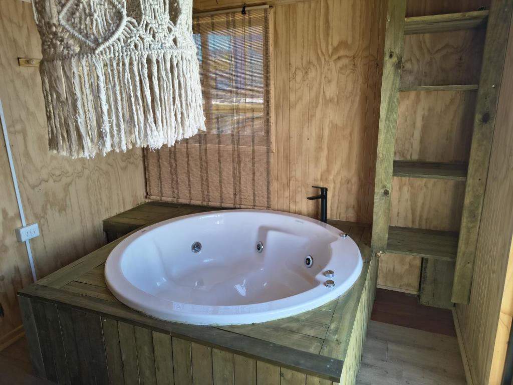 una grande vasca in un bagno con finestra di Cabaña Jacinta a La Boca
