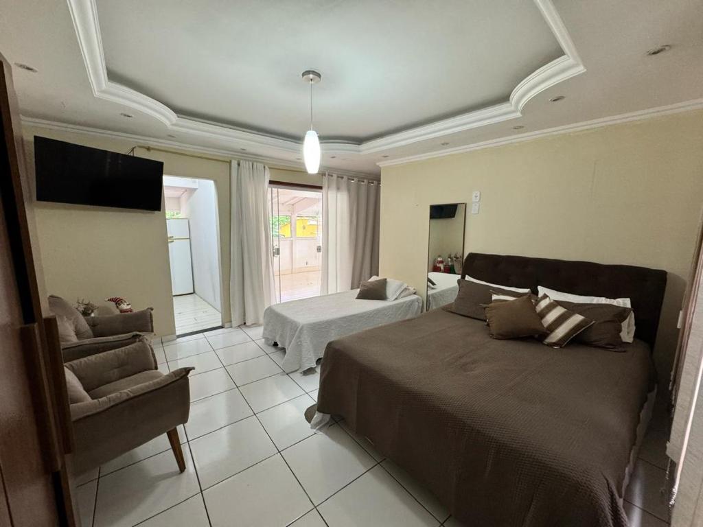 een slaapkamer met een bed, een bank en een tv bij Loft Ilha Grande in Angra dos Reis