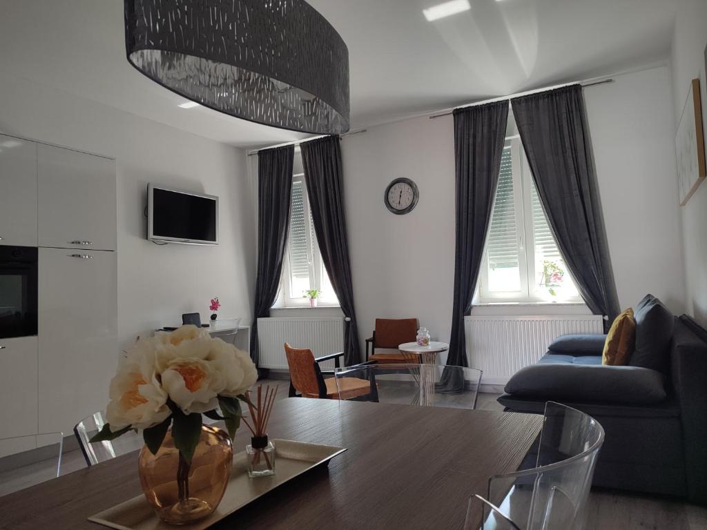 un soggiorno con un vaso di fiori su un tavolo di Rondela Osijek a Osijek