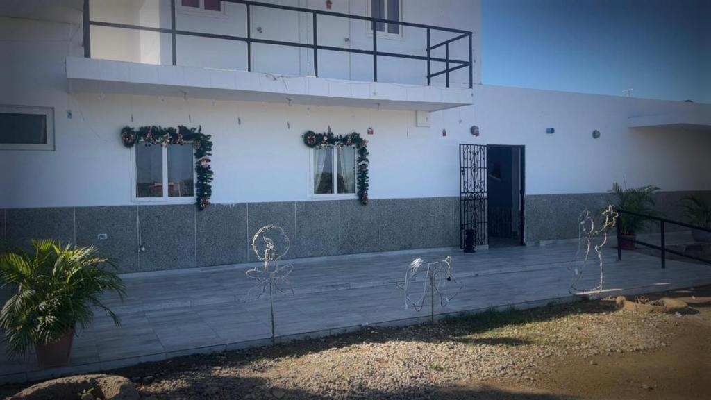 ein Gebäude mit Veranda und Tür mit Pflanzen in der Unterkunft Brisas de Uribia in Uribia