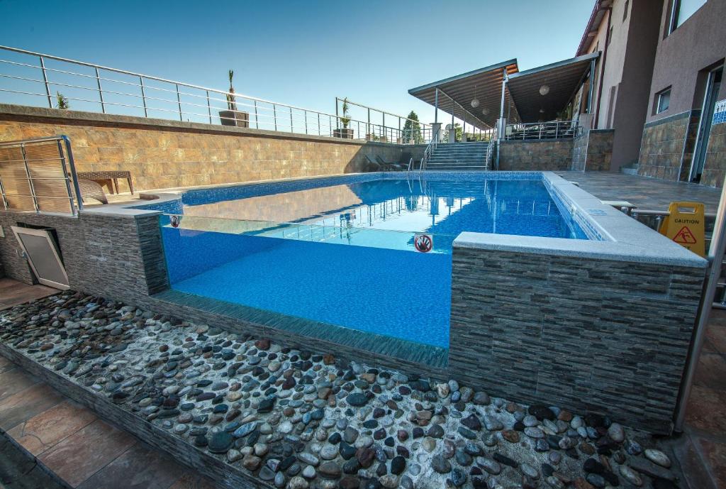 ein Pool mit blauem Wasser und Felsen in der Unterkunft Hotel Pamela Concept in Negotino