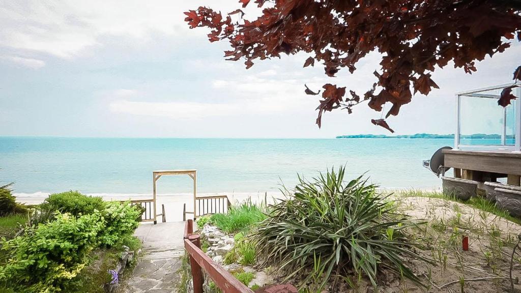 a path to the beach with the ocean in the background at Cottage on Crystal Beach 3BR & BBQ in Fort Erie