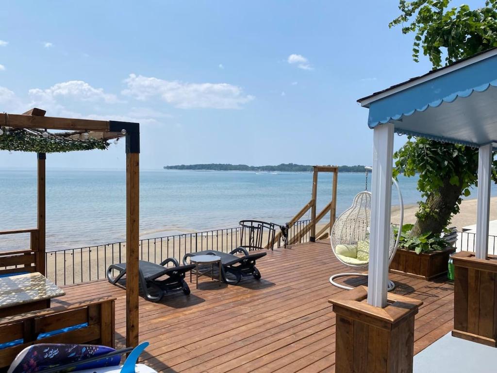 a wooden deck with a view of the beach at Water Front Beach House - 3BR w BBQ & Sunset in Fort Erie