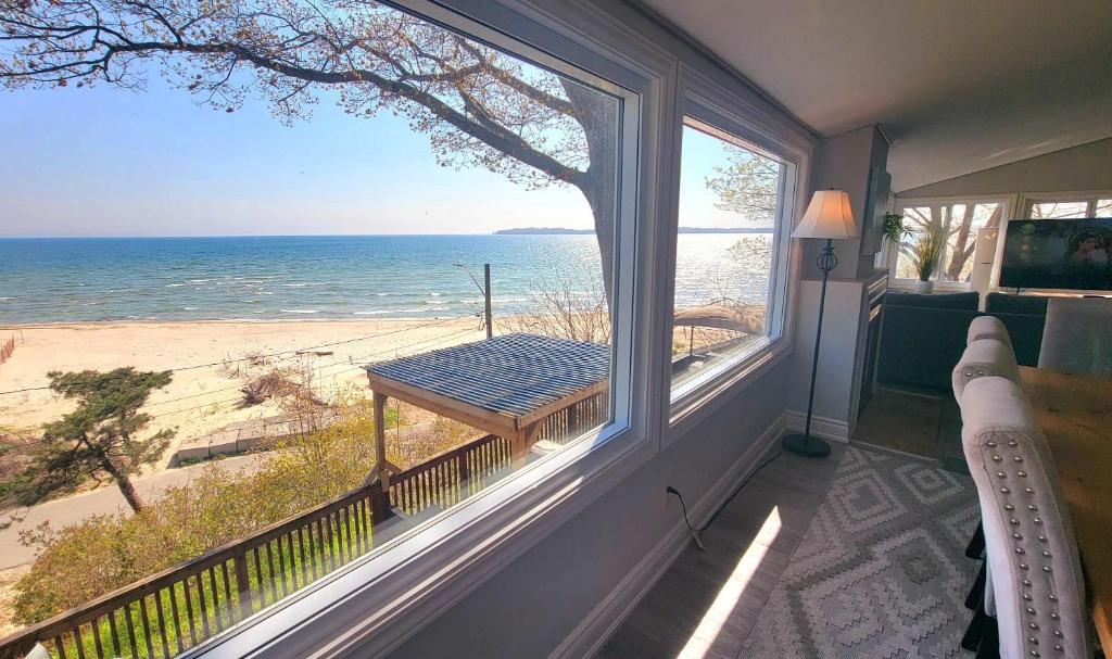 a balcony with a view of the beach and the ocean at Crystal Beach Waterfront Cottage - Sunset Views in Fort Erie