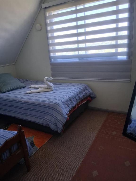 a bedroom with a bed with a white swan on it at Búho Real Cityhouse in El Cerrillo