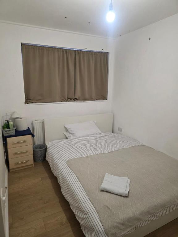 a bedroom with a bed with two towels on it at Spacious room in London
