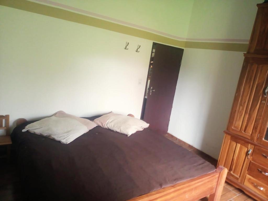 una camera da letto con un letto con due cuscini sopra di Wasi a Samaipata