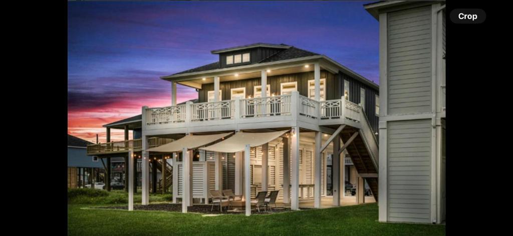 a large house with a deck with umbrellas at Perfect Beach Getaway Home! in Crystal Beach